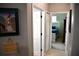 Hallway view with a framed beach photo, doors to closets and a bedroom with a blue bedspread at 1884 Coconut Palm Cir, North Port, FL 34288