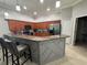 Well-lit kitchen with granite countertops, wooden cabinets, breakfast bar seating and stainless steel appliances at 1884 Coconut Palm Cir, North Port, FL 34288