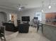 Bright living room with tile flooring, a modern ceiling fan, and open-concept design connecting to the kitchen area at 1884 Coconut Palm Cir, North Port, FL 34288