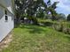 Spacious backyard with a lush green lawn and mature trees offering shade and privacy at 2308 18Th E St, Bradenton, FL 34208