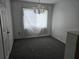 Dining room with gray carpet, chandelier, and window covered with a white sheet at 2308 18Th E St, Bradenton, FL 34208