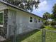 Side of the home featuring the unique stone facade, complemented by a metal chain link fence at 2308 18Th E St, Bradenton, FL 34208