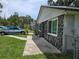 Side view of the home highlighting the stone facade, clean lines and the adjacent concrete walkway at 2308 18Th E St, Bradenton, FL 34208