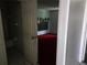 Hallway with tile flooring, and a view of a bedroom with red carpet at 2308 18Th E St, Bradenton, FL 34208