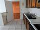 Kitchen with stainless steel sink and wooden cabinets and adjacent carpeted room at 2308 18Th E St, Bradenton, FL 34208