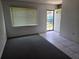 Living room featuring carpet, a window with blinds, and security door access at 2308 18Th E St, Bradenton, FL 34208