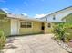Backyard area with a concrete tile patio, a door and windows with green siding, and some landscaping at 2710 W North A St, Tampa, FL 33609