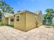 View of the backyard area with green siding, a concrete tile patio, and a small tree at 2710 W North A St, Tampa, FL 33609