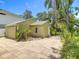 Home's backyard featuring a spacious tiled patio, detached garage and verdant tropical landscaping at 2710 W North A St, Tampa, FL 33609
