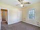 This bedroom is spacious and features neutral carpet, overhead fan, and a window with a view of the neighborhood at 2710 W North A St, Tampa, FL 33609