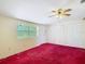 Empty bedroom with red carpet, ceiling fan, closet, and natural light from one window at 2710 W North A St, Tampa, FL 33609