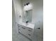 Bathroom featuring a single sink, white cabinets with black fixtures, a mirror and marble floors at 16475 Hillsborough Blvd, Port Charlotte, FL 33954