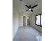 Bright bedroom featuring white marble tile floors, modern ceiling fan, and a window with a dark frame at 16475 Hillsborough Blvd, Port Charlotte, FL 33954