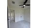 The bedroom has a ceiling fan with marble floors and white paint with black fixtures at 16475 Hillsborough Blvd, Port Charlotte, FL 33954