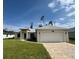 This beautiful single Gathering home features a 2-car garage, well manicured lawn and a concrete driveway at 16475 Hillsborough Blvd, Port Charlotte, FL 33954