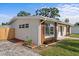 Side exterior with wood accents, well-maintained landscaping, and sidewalk at 1740 Lucas Dr, Clearwater, FL 33759