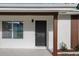 Close-up of a modern front door framed by updated windows and freshly painted trim, enhancing curb appeal at 1740 Lucas Dr, Clearwater, FL 33759