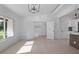 Sunlit living area with tile floors, connecting to a kitchen, accentuated by modern lighting fixtures and white trim at 1740 Lucas Dr, Clearwater, FL 33759