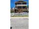 Charming multi-level home featuring multiple decks, brown siding, and a quaint white picket fence at 19105 Whispering Pines Dr, Indian Shores, FL 33785