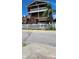Attractive home featuring multiple decks, brown siding, a white picket fence, and mature landscaping at 19105 Whispering Pines Dr, Indian Shores, FL 33785