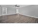 Spacious bedroom featuring wood-look tile flooring and a ceiling fan, leading to a bathroom at 1937 N Highland Ave, Clearwater, FL 33755