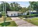 Quaint single-story home featuring mature landscaping, a paved driveway, and a welcoming facade at 1937 N Highland Ave, Clearwater, FL 33755