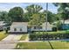 Inviting single-story home with a meticulously manicured front yard, mature landscaping, and a paved driveway at 1937 N Highland Ave, Clearwater, FL 33755