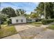 Single-story home features a classic design with a paved driveway and mature trees, set on a well-maintained lawn at 1937 N Highland Ave, Clearwater, FL 33755