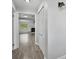 Bright hallway features plank flooring and white trim, leading to a glimpse of the cozy living area at 1937 N Highland Ave, Clearwater, FL 33755