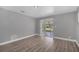 Living room showcasing wood-look floors, neutral gray walls, and view to a sunroom at 1937 N Highland Ave, Clearwater, FL 33755