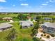Expansive aerial view of home near a golf course; showcases lush landscaping, manicured lawns, and serene surroundings at 27 Bunker Ct, Rotonda West, FL 33947