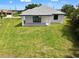Backyard of this single-Gathering home, with new lawn and black framed sliding glass doors at 27 Bunker Ct, Rotonda West, FL 33947