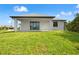 Backyard featuring grass lawn, patio and view into the home at 27 Bunker Ct, Rotonda West, FL 33947