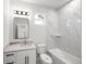 A bathroom with marble-look tiling on the walls, a single sink, and a shower/tub combo at 27 Bunker Ct, Rotonda West, FL 33947