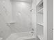 Bright bathroom featuring modern fixtures, shelving, and marble-look tiled shower and tub combo at 27 Bunker Ct, Rotonda West, FL 33947