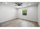 Clean, bright bedroom with a ceiling fan and large window providing a view of the backyard at 27 Bunker Ct, Rotonda West, FL 33947