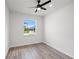 Clean, bright bedroom with a ceiling fan and large window providing a view of the front of the house at 27 Bunker Ct, Rotonda West, FL 33947
