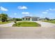 Expansive paved driveway leads to this modern single-story home with well-maintained landscaping on a bright day at 27 Bunker Ct, Rotonda West, FL 33947
