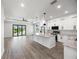 Modern kitchen features granite countertops, an island, white cabinetry, stainless steel appliances, and an open layout at 27 Bunker Ct, Rotonda West, FL 33947