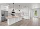 A modern white kitchen features granite countertops, a central island, and stainless steel appliances at 27 Bunker Ct, Rotonda West, FL 33947