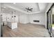 Bright, open-concept living room with modern fireplace, sleek ceiling fan, and seamless access to the outdoors at 27 Bunker Ct, Rotonda West, FL 33947