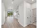 Open-concept living space offers a modern kitchen, wood-look flooring, and sliding doors to the backyard at 27 Bunker Ct, Rotonda West, FL 33947