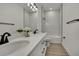 Bathroom featuring a double vanity, a walk-in shower, and modern light fixtures at 9739 Loretto St, Spring Hill, FL 34608