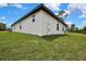 Back side of a modern, white home with well maintained lawn and blue skies at 9739 Loretto St, Spring Hill, FL 34608