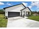 Home with large garage, well manicured lawn, and inviting front porch at 9739 Loretto St, Spring Hill, FL 34608