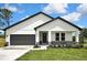 Charming single-story home featuring a modern design, a two-car garage, and a well-manicured lawn at 9739 Loretto St, Spring Hill, FL 34608