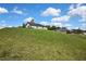 White modern farm house set on a hill of bright green grass under a blue sky at 9739 Loretto St, Spring Hill, FL 34608