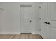 Hallway featuring light-colored wood floors, white walls, and doorways for a modern design at 9739 Loretto St, Spring Hill, FL 34608