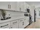 Kitchen featuring white cabinets, black hardware, and modern appliances at 9739 Loretto St, Spring Hill, FL 34608