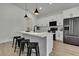 Modern kitchen features white cabinets, a kitchen island, black hardware, stainless steel appliances, and hardwood floors at 9739 Loretto St, Spring Hill, FL 34608